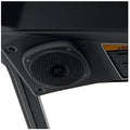 Black overhead audio enclosure shown with an integrated round speaker and protective metal grille. The low-profile housing fits neatly along the front roof area of the Defender cab.